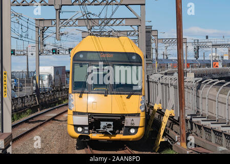 Ein Waratah eine Reihe Doppelstockzug verlässt die Sydney Harbour Bridge und Ansätze Milsons Point Station auf der nördlichen Seite der Hafen, Stockfoto