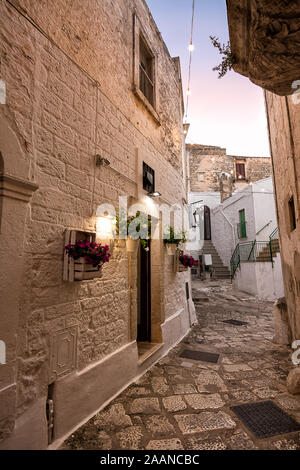 Blick auf eine typische Gasse von Ceglie Messapica (Italien) bei Sonnenuntergang Stockfoto