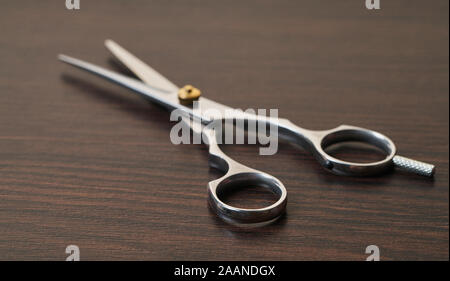 Neue Friseur Schere close-up auf einem hölzernen Hintergrund Stockfoto