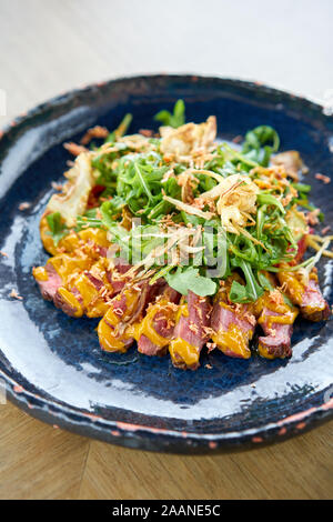 Gebratenes Rindfleisch, Gemüse, Karotte und Austernsauce. In Scheiben geschnitten gegrilltes Rindfleisch Grill Roastbeef Steak und Salat mit Rucola. Stockfoto