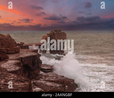 Portland Bill Dorset England Wellen gegen Pulpit Rock auf einer luftigen November Morgen Stockfoto