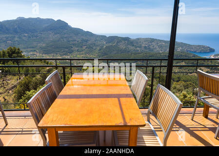 Leere Tische mit Blick über die Bucht von Port de Soller an der Westküste von Mallorca. Spanien Stockfoto