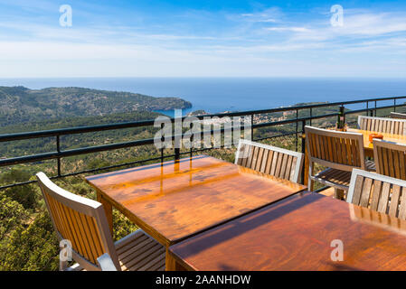 Leere Tische mit Blick über die Bucht von Port de Soller an der Westküste von Mallorca. Spanien Stockfoto