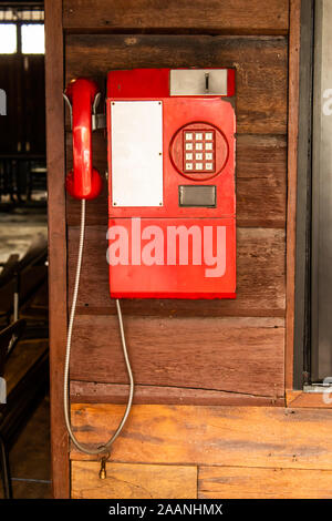 Alten roten Telefon auf einer Holzwand. Stockfoto