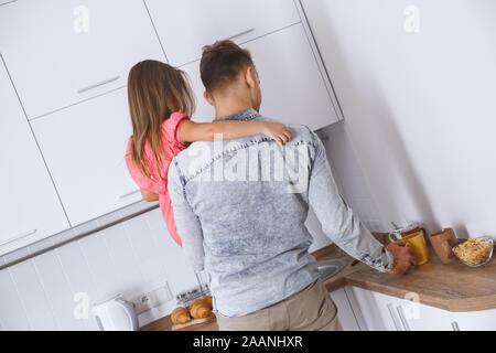 Kleines Kind Mädchen mit Vater zu Hause Kindheit Konzept vorbereiten Essen Stockfoto