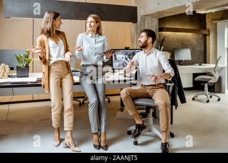 Kreative Mitarbeiter arbeiten an einigen architektonischen Projekt, im Gespräch am Arbeitsplatz des modernen Büros Studio. Konzept eines architektonischen Business und kreatives Arbeiten Stockfoto