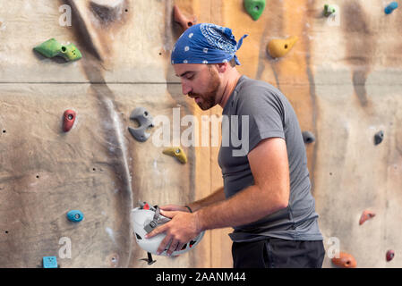 Sportliche Menschen üben indoor Klettern in der Kletterhalle. Stockfoto