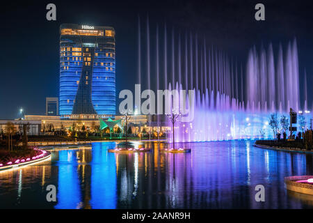 Taschkent, Usbekistan - 30 Oktober, 2019: schöne Springbrunnen bei Nacht mit Reflexion im Teich beleuchtet in neuen Taschkent City Park Stockfoto