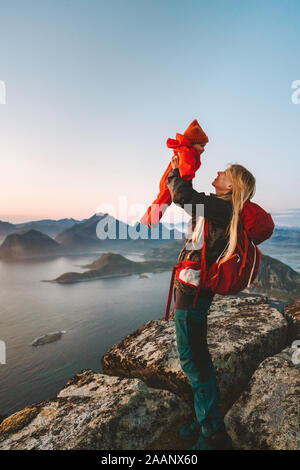 Mutter Holding up baby Reisen Wandern in den Bergen Familie gesund Lifestyle Mom mit Rucksack und Kind aktiv Urlaub im Freien in Norwegen Lofo Stockfoto