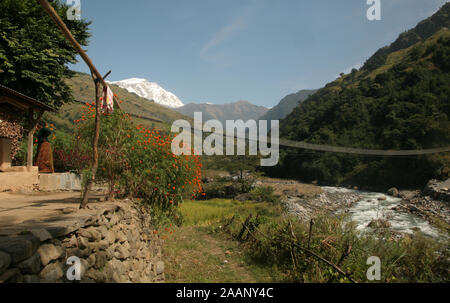 Fußgängerbrücke über Madi River, mit Lamjung Himalaya im Hintergrund. Annapurna region, Nepal Stockfoto