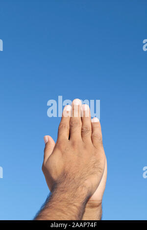 Junger Mann die gefalteten Hände vor blauem Himmel Stockfoto