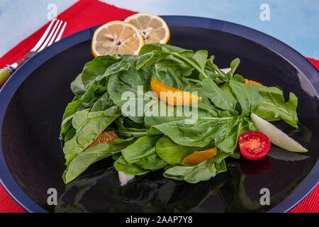 Rucola Salat. Rucolasalat mit Parmesan, Zitrone, Olivenöl und Gewürzen auf Holz- Hintergrund. Vegetarisches Essen. Stockfoto