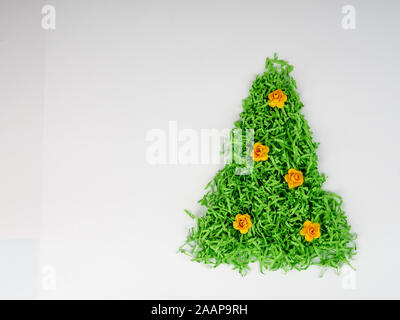 Grüner Weihnachtsbaum mit Blumen aus geschreddertem Papier Konzept der sparsamen Nutzung von Ressourcen, glückliches neues Jahr, Recycling, separate Müllabfuhr Stockfoto