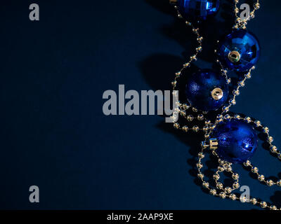 Blaue Weihnachtskugel mit silbernen Perlen. Bokeh-Effekt auf dunklem Hintergrund. Copyspace für Ihre Begrüßung oder Wünsche, Banner Stockfoto
