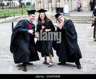 Eine Gruppe von Happy New York St John University Absolventen tragen Kleider und Hüte Mortarboard auf ihrer Abschlussfeier an der York Minster Stockfoto