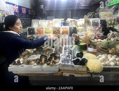 Peking, China. 23 Nov, 2019. Ein chinesischer Pilz Anbieter wartet auf Kunden bei einer der großen Märkte in Peking am Samstag, 23. November 2019. China hat seine Schätzung der Größe der Verlangsamung der Wirtschaft um rund 2 Prozent erhöht Nach einer nationalen wirtschaftlichen Volkszählung, trotz Chinas Wirtschaft auf die langsamste seit 1992 wächst. Die Verlangsamung der Wirtschaft hat den Verbrauchern schaden als die Lebenshaltungskosten, insbesondere Lebensmittel, setzt pro Haushalt zu erhöhen. Foto von Stephen Rasierer/UPI Quelle: UPI/Alamy leben Nachrichten Stockfoto