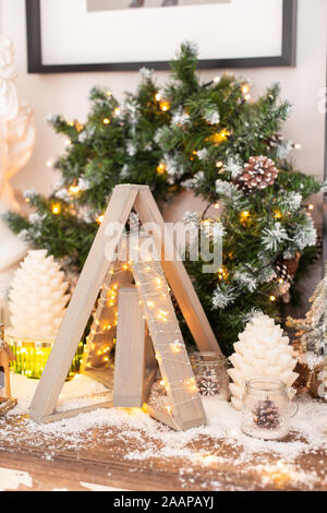Pyramide aus Holz und ein paar Kegel stehen auf der Kommode vor der Kranz. Stockfoto