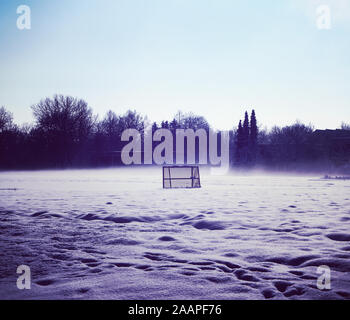 Winter im ländlichen Bayern, amatorial Fußballfeld durch Schnee und morgen Nebel Stockfoto