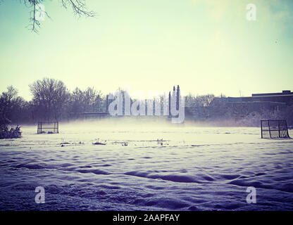 Winter im ländlichen Bayern, amatorial Fußballplatz coverwev durch Schnee und Morgennebel Stockfoto