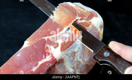 Schneiden jamon mit Messer Stockfoto