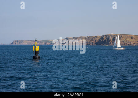 Yachtcharter Segeln in einem ruhigen Meer vorbei an der Boje aus Runnelstone Gwennap Kopf: Land's End, Cornwall, Großbritannien Stockfoto