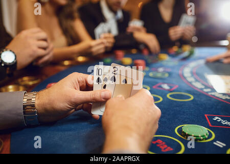 Hände eines Poker Spieler Kontrolle Karten in einem Casino. Stockfoto