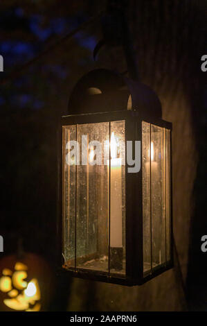Altmodische, Kerzenlicht und Laternen beleuchtet, mit einer einzigen, geschnitzt und beleuchtete Halloween Kürbis im Hintergrund Stockfoto