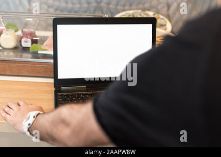 Bussinesman mit seinem Laptop im Büro, am Schreibtisch mit leerem Display platziert. Stockfoto