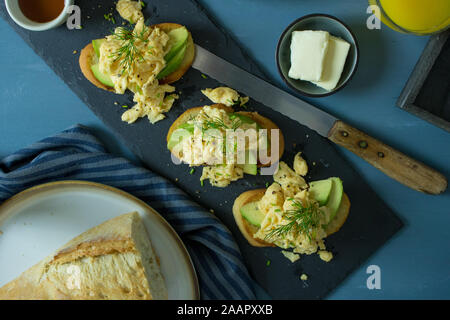 Essen Fotografie von Rührei und Avocado Toast auf einem blauen Hintergrund Stockfoto