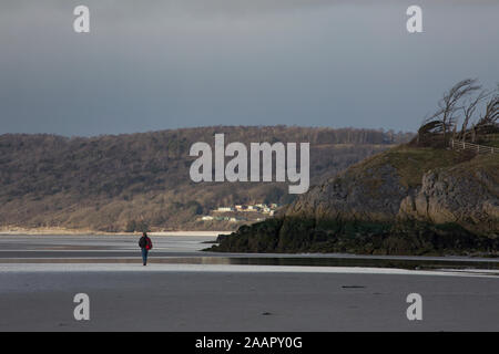 Ein Blick auf die Küste in der Nähe des Dorfes Silverdale und Jenny Brown's Point bei Ebbe mit einem einsamen Mann gehen über den Sand. Lancashire En Stockfoto