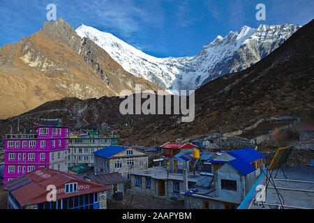 Kleinen Dorf Kyanjin Gompa im Schatten der Berge mit blauen Dächern und Rosa Haus Stockfoto