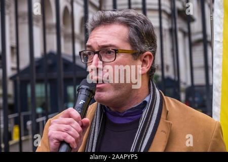 London, Großbritannien. 23. November 2019. Hong Kong Watch Gründer Benedikt Rogers spricht vor den Toren von Downing St. Hunderte von schwarz gekleideten Demonstranten protestieren auf einer Kundgebung vor den Toren von Downing Street, wo Sie in einem Schreiben aufgefordert, die Premierminister über Chinas Verletzung der Chinesisch-britischen Gemeinsamen Erklärung zu handeln. Sie wies auf die humanitäre Krise in Hong Kong, weit verbreiteten Ungerechtigkeiten und Aushöhlung der Autonomie und forderte die Hong Kong Demonstranten 5 Anforderungen erfüllt werden. Peter Marshall / alamy Leben Nachrichten Stockfoto