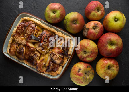 Ein Apfelkuchen mit mürbteig Gebäck, Zitronensaft, braunem Zucker und Äpfel, die freundlicherweise außerhalb eines Hauses mit einem Obstgarten gelassen wurde und angesichts der Awa Stockfoto