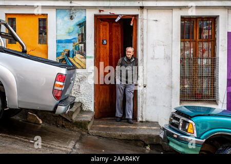 Ein Mann lehnt sich gegen seine Tür, Valparaiso, Chile Stockfoto