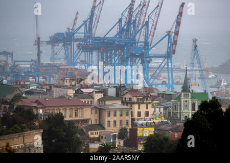 Kräne Container in der hohen Verkehr Hafen von Valparaiso, Chile zu heben. Stockfoto