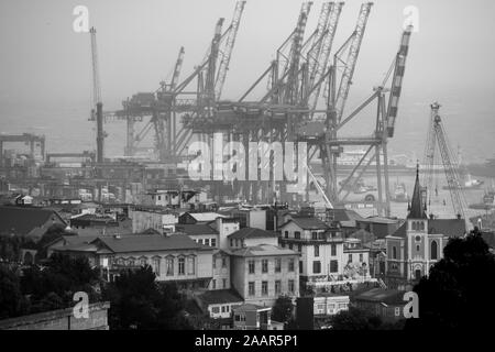 Kräne Container in der hohen Verkehr Hafen von Valparaiso, Chile zu heben. Stockfoto