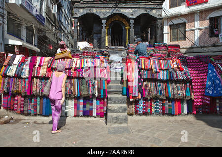 Männer verkaufen Stapel von bunten Stoffen in der Altstadt von Kathmandu Stockfoto