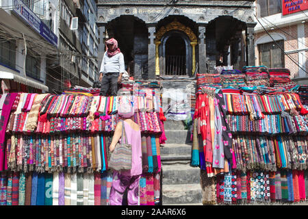 Männer verkaufen Stapel von bunten Stoffen in der Altstadt von Kathmandu Stockfoto