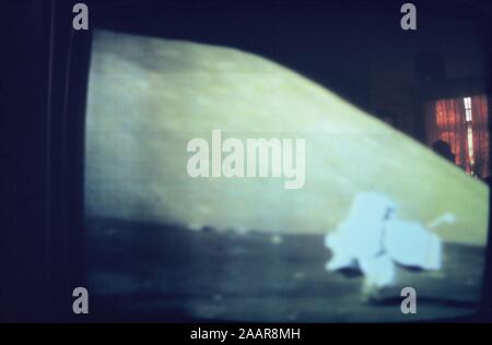 Teleclip - Apollo 11 Felsenmusterstück Neil Armstrong auf dem Mond - Foto direkt vom TV-Bildschirm sehen Sie die Reflexion des orangefarbenen Vorhängen in den Hintergrund und die Silhouette der Person, die die TV-Sendung, die die Mondlandung/s - ca. 1969-72 Stockfoto