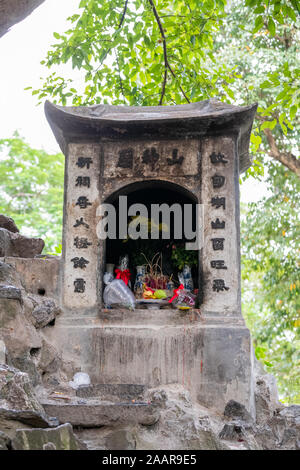 Ein Schrein mit Geschenken und Angebote in der Nähe des Jade Mountain Tempel in Hanoi, Vietnam gefüllt Stockfoto