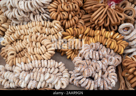 Auswahl von verschiedenen Aromen von frischen Bagels auf einem Tisch. Bagels. Trockene Bagels, trocknen. Ausstellung von Lebensmitteln. Food-fotografie. Kaffee oder Tee Swee Stockfoto