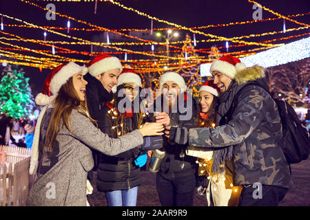Eine Gruppe von Freunden trinken heißen Tee auf einer Messe in Weihnachten Stockfoto