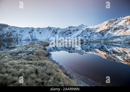 Schönen Sonnenuntergang mit Blick auf die verschneite Bergwelt in Angelus Seen in der Nähe von Angelus Hut im Nelson Lakes National Park, Neuseeland wider Stockfoto