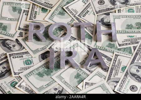 Die Worte ROTH IRA mit Aluminium Buchstaben auf den US-Dollar festgelegt Banknoten Hintergrund - mit selektiven Fokus. Stockfoto