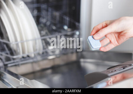 Frau putting Tablet in der Spülmaschine Reinigungsmittel, Stockfoto