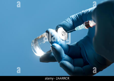 Krankenschwester bereitet die Flüssigkeit in die Spritze aus der Durchstechflasche ziehen. Stockfoto