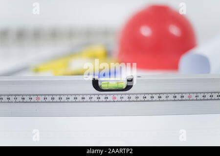 Architekturbüro Schreibtisch, Tisch mit Construction Tools, rot Helmkonstruktion, Kugelschreiber, Bleistift, Lineal und Papierrolle. Geschäftskonzept. Stockfoto