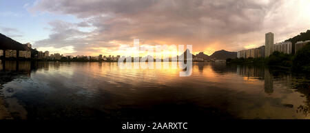 Dramatischer Sonnenuntergang über der Stadt See von Rio de Janeiro Lagoa Rodrigo de Freitas mit der intensiven orange Farben im Wasser widerspiegelt Stockfoto