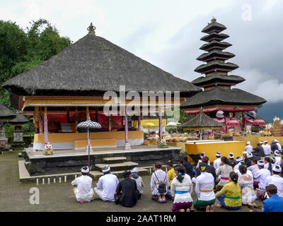 BEDUGUL, Indonesien März, 15, 2018: Hindu Anbeter in einem Innenhof von Pura Danu Bratan Tempel sitzen in Bali. Stockfoto