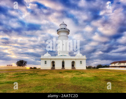 Fassade des ersten australischen Macquarie Lighthouse in Sydney gegen bewölkter Himmel bei Sonnenaufgang - historisches Wahrzeichen, gebaut aus weißen Steinen. Stockfoto